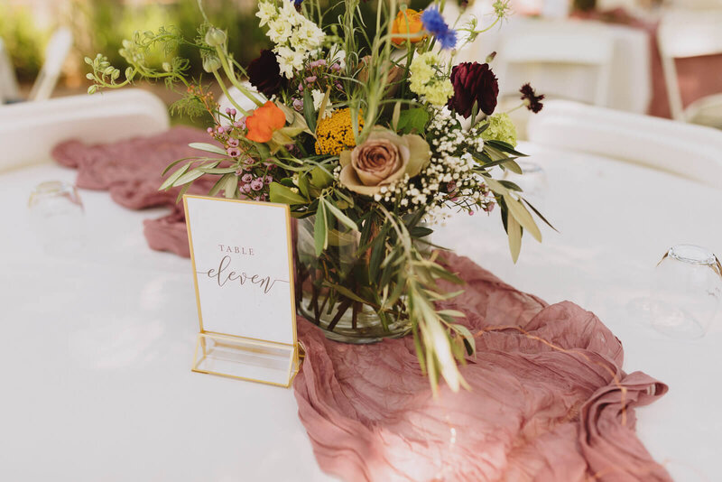 Wedding reception table decor of flowers and gold frame