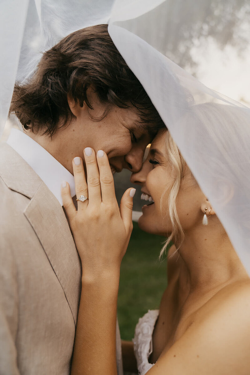 Bride grazes her husband's cheek as they stand forehead to forehead