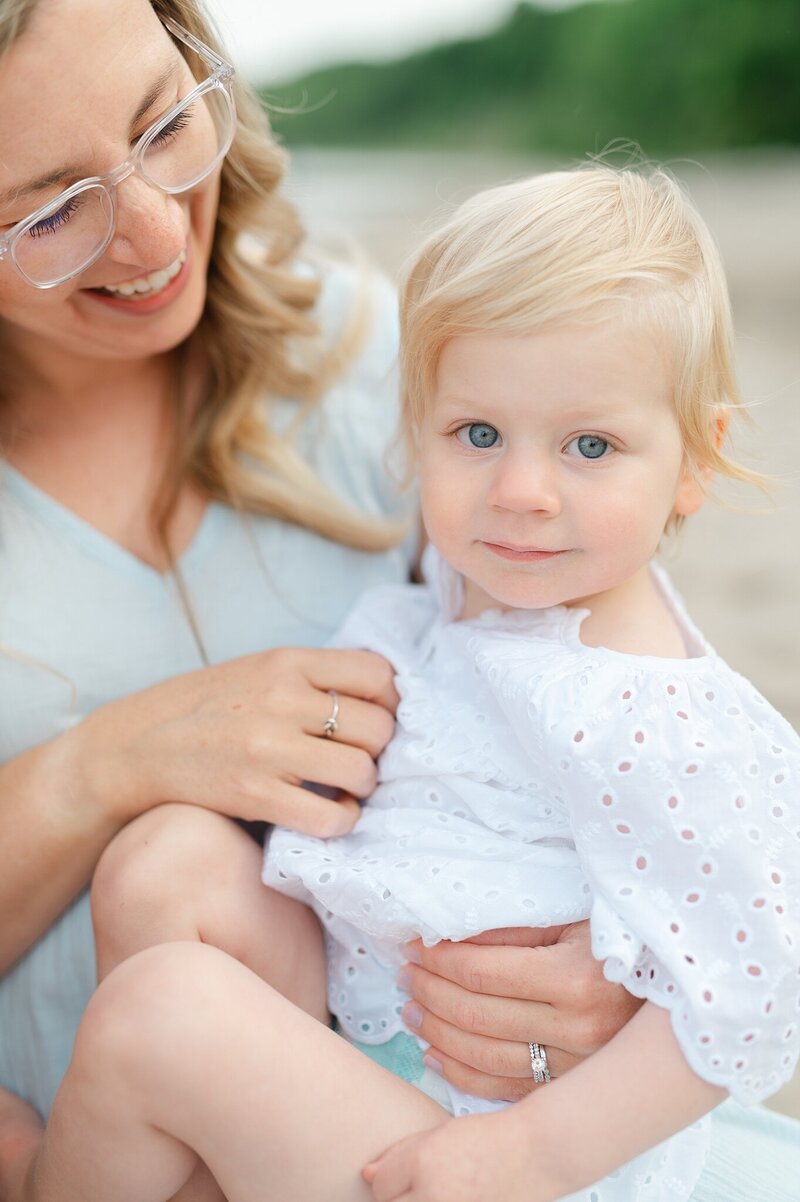 Mom smiling at the daugher in her lap at Grant Park beach during a family photography session