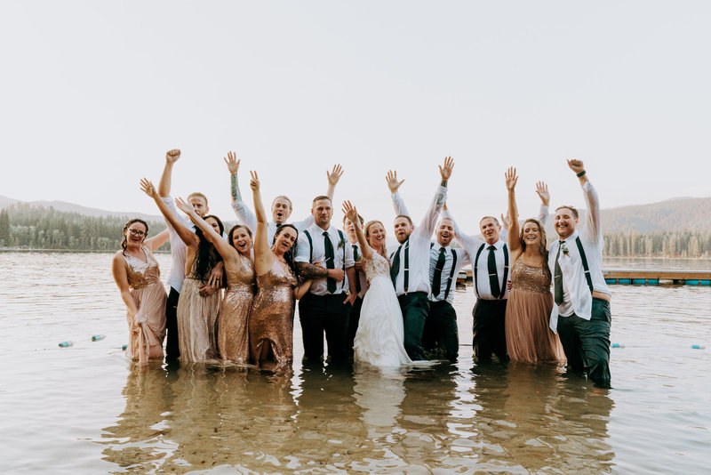 Bridal party jumping into lake after wedding reception in McCall Idaho, photo by photographer Kaitlyn Neeley