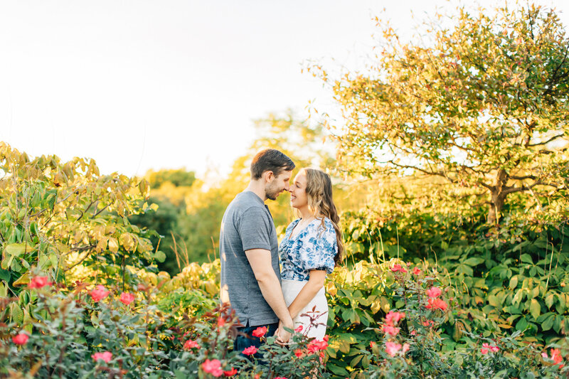 Man and woman hold hands while standing in a flower garden