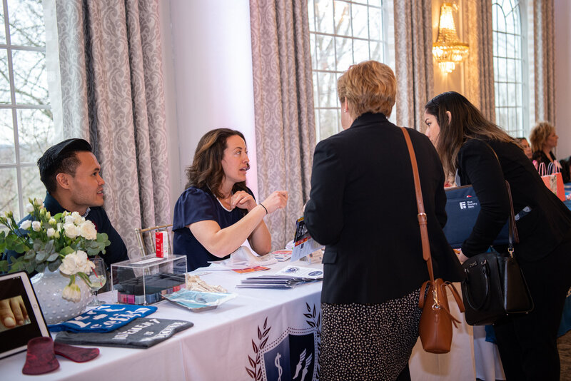 A vendor talking to the attendees at an International Women's Day Business Summit.