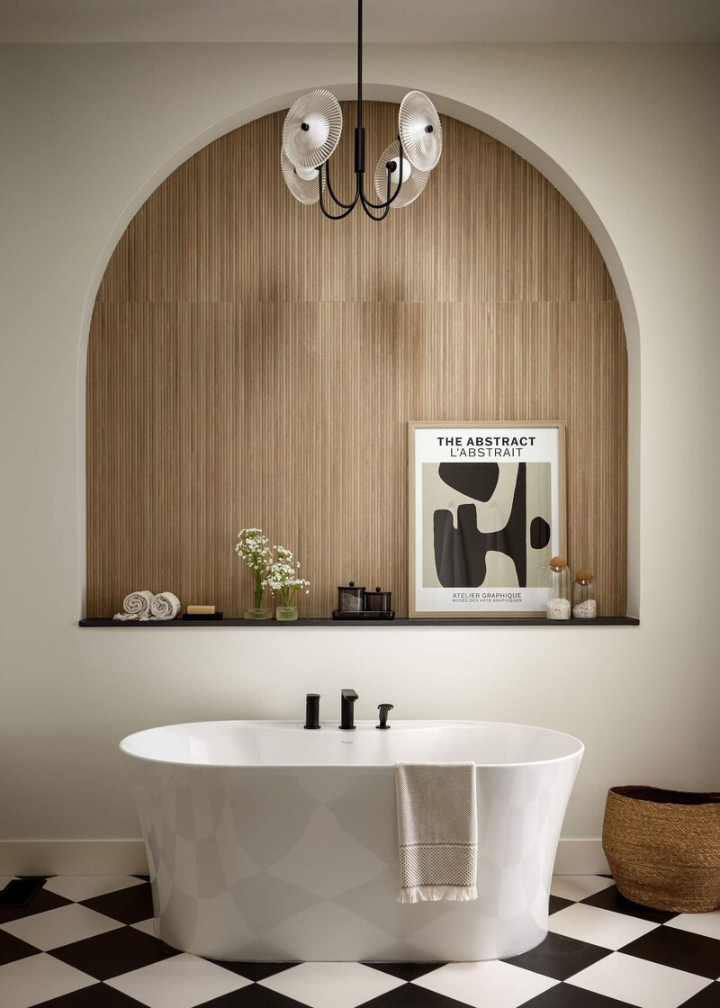 A gorgeous ensuite with an arch focal point paired with fluted tile and black and white checker tile. 