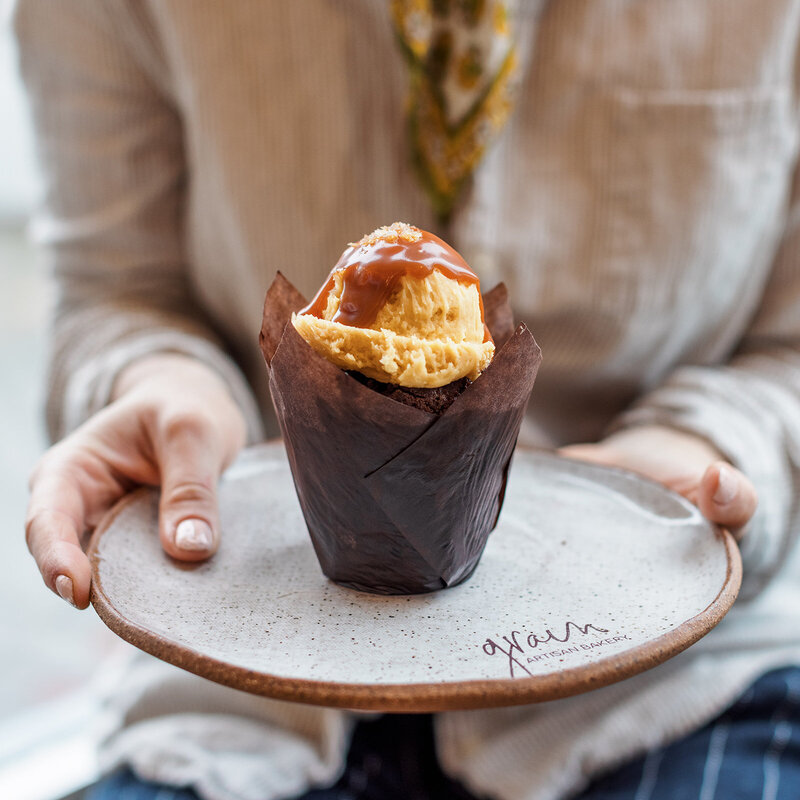 Close-up of a salted caramel gluten-free muffin served on a ceramic plate at Grain Artisan Bakery in Snohomish, Washington.