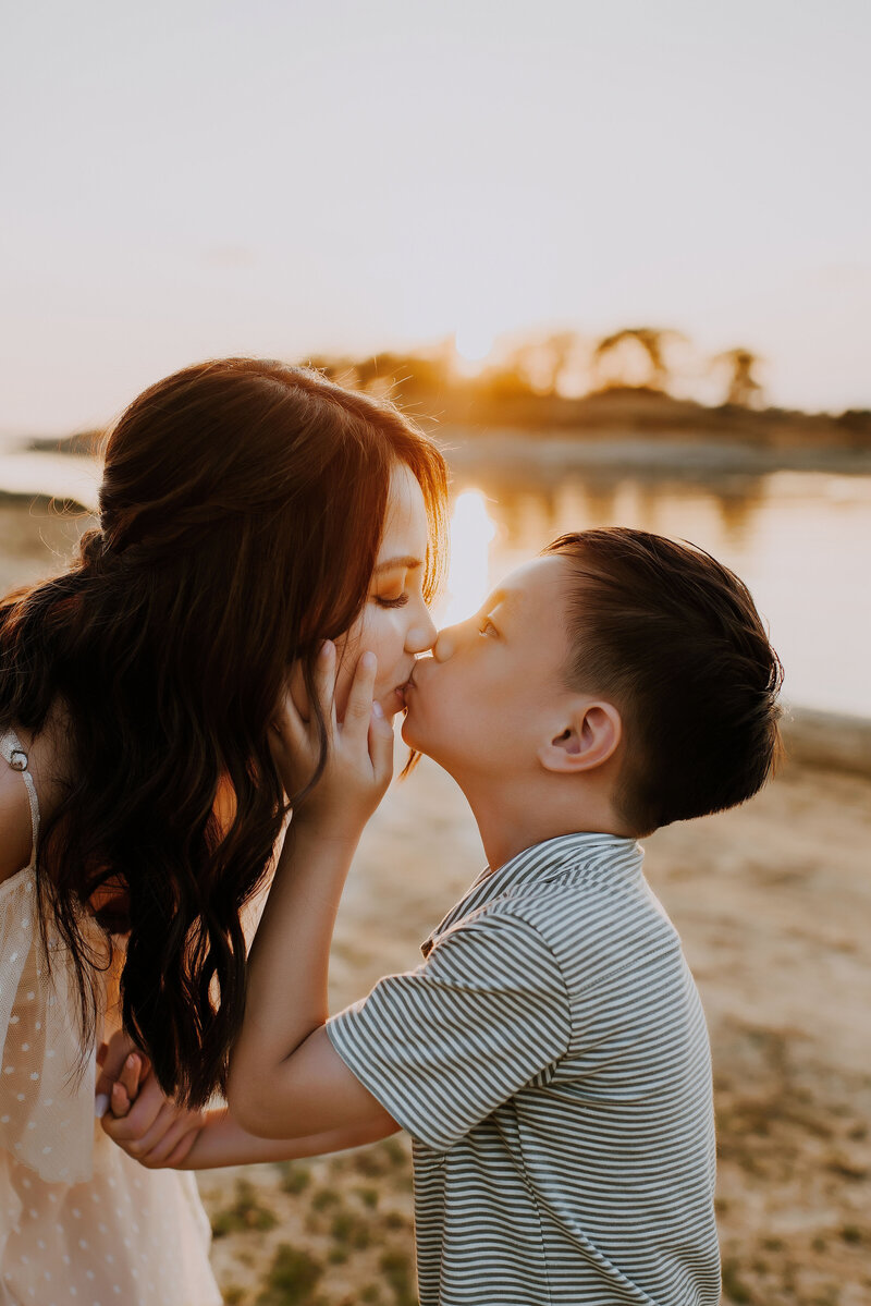 A young boy giving his mom a kiss.