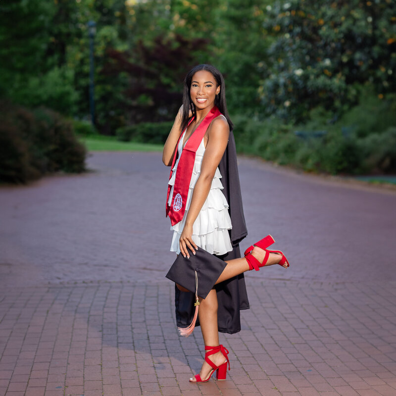 A University of South Carolina student posing for her senior portrait on campus at the historic horseshoe