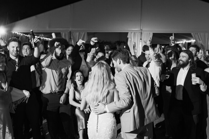 Newlyweds embrace on the dance floor, surrounded by celebration