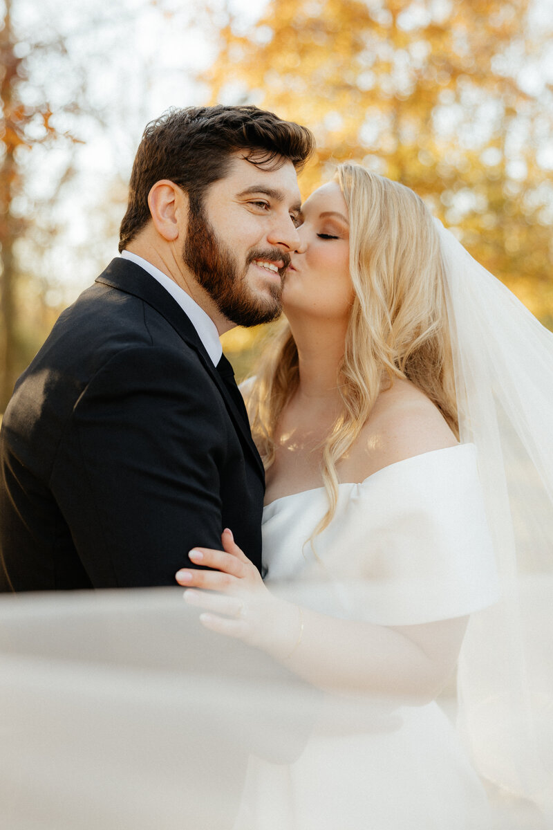 A bride kissing her groom's cheek.