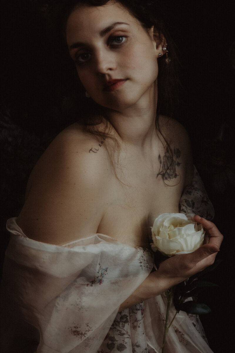 Ritratto di donna che tiene una peonia bianca, indossa abito floreale leggero – stile fine art.