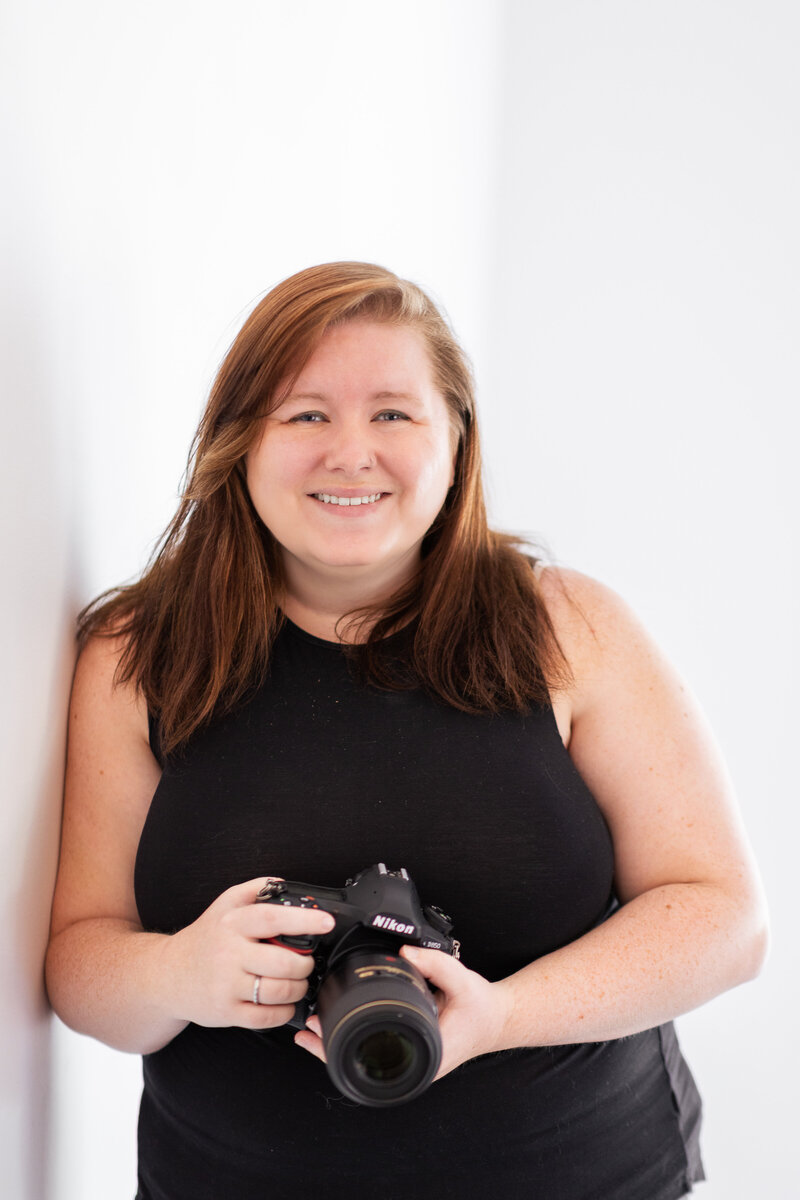 Melissa Cook, a Northern VA and Leesburg Wedding Photographer, Posed with sunglasses, a camera, laptop and disco ball