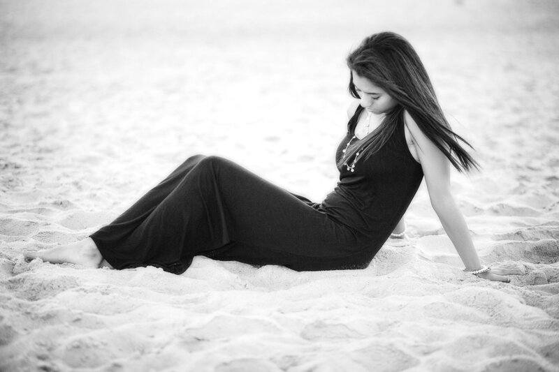B&W image of girl in black dress on the beach
