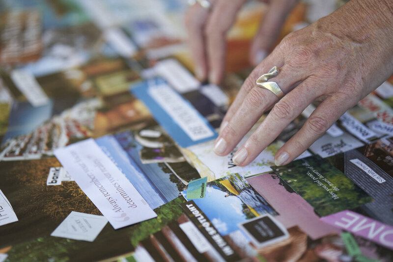 Close-up of Laura Kate McHugh’s hands pointing at a vision board, symbolizing clarity, intention, and subconscious alignment