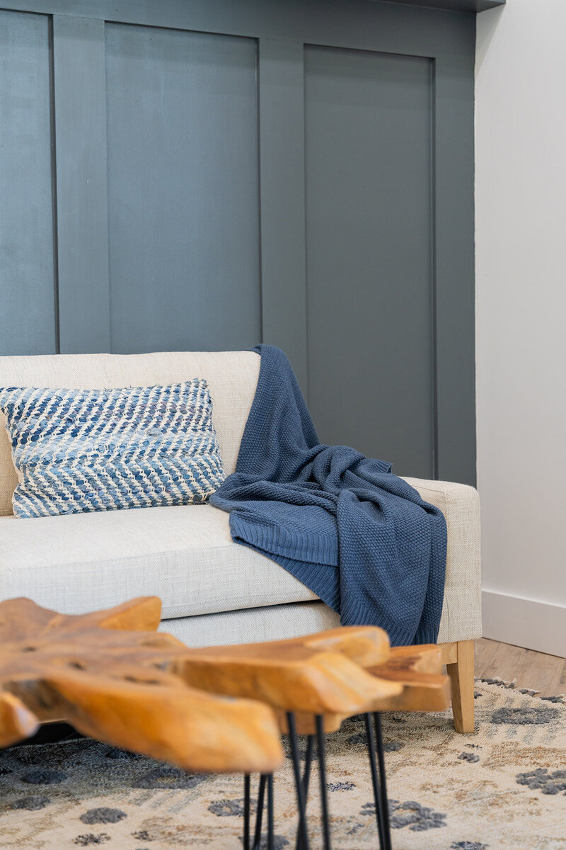 Blue wall with white couch and blue accents