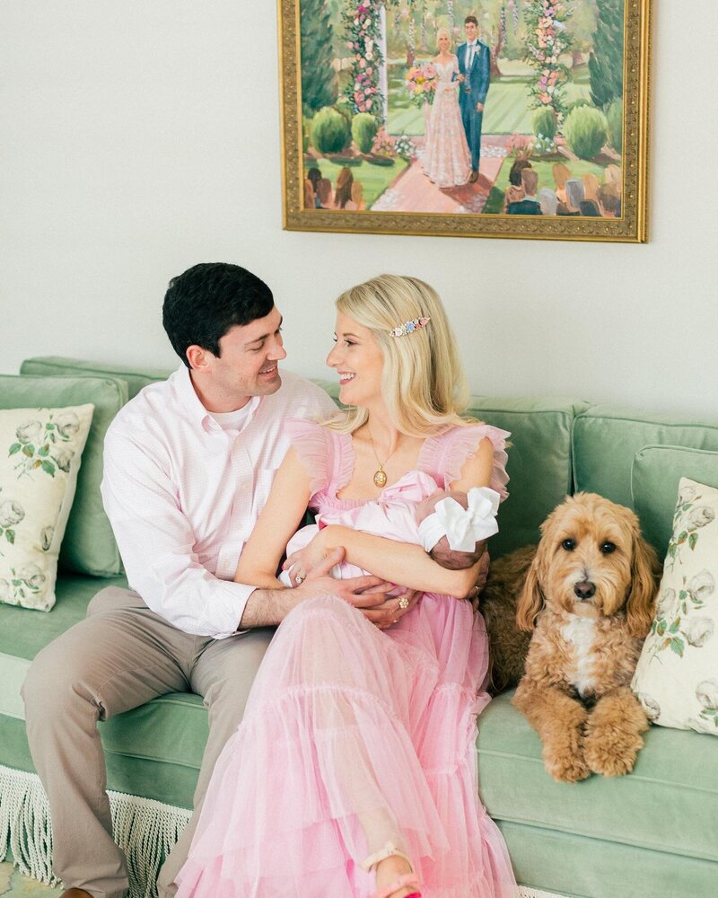 couple sitting on couch with dog and baby