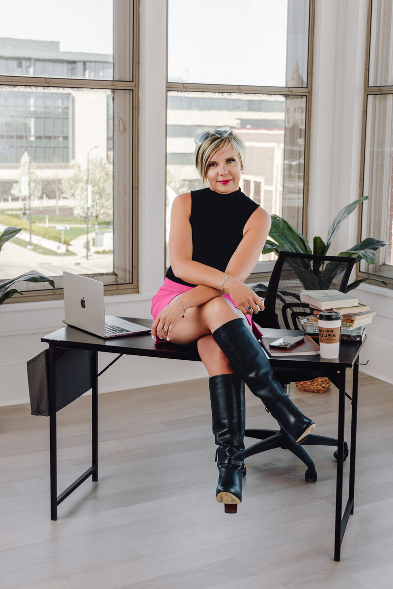 Natalie laughing on a bench outside of coffee shop