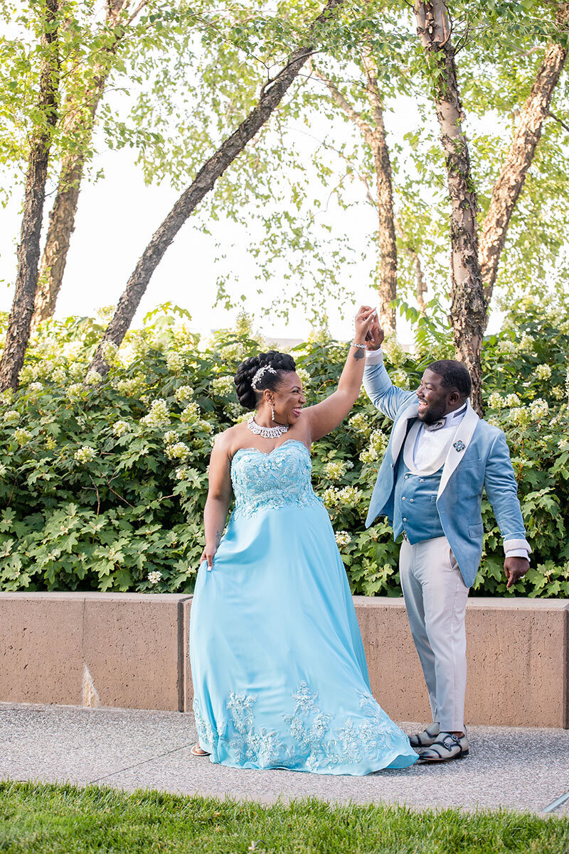 Wedding photo of couple on  pier twirling in blue wedding dress