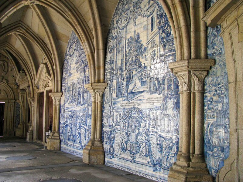 Gothic cloister in Porto adorned with intricate blue-and-white azulejo tile murals depicting historical and religious scenes ©Stephanie Dosch | theViatrix Porto Luxury Travel Guide