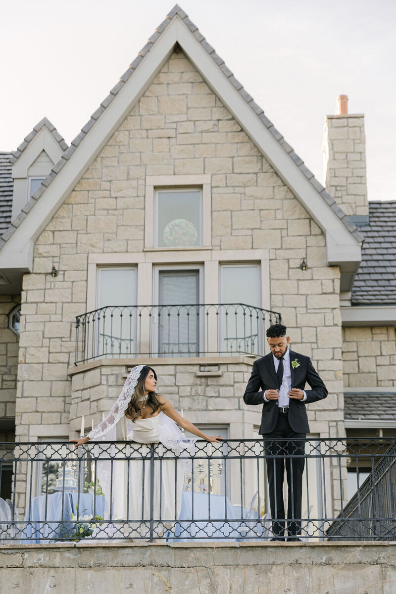 Bride and groom posing on stone balcony at Greystone Castle in Boulder, Colorado — editorial wedding photo by a Colorado wedding photographer.