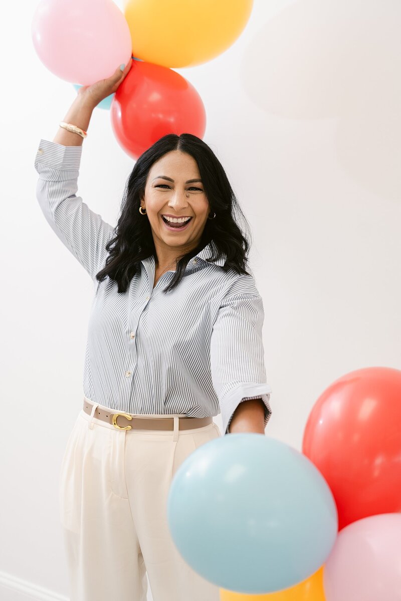 Woman holding balloons at her brand session