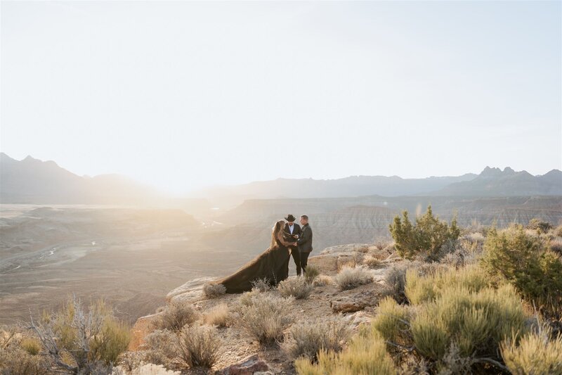 Couple during sunset at their elopement with an officiant speaking.