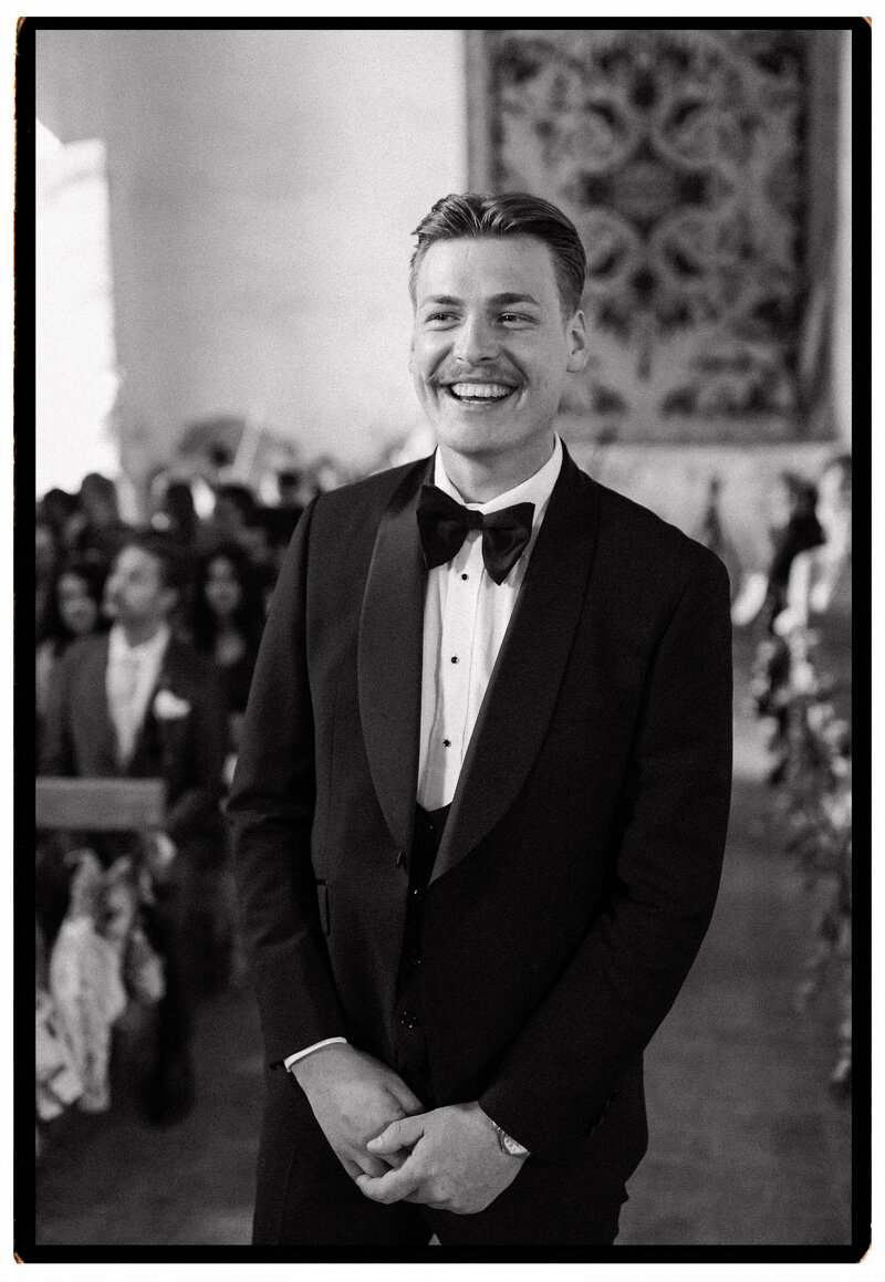 A groom stands at the altar waiting for his bride in an 10th century church chateau du queille south of france