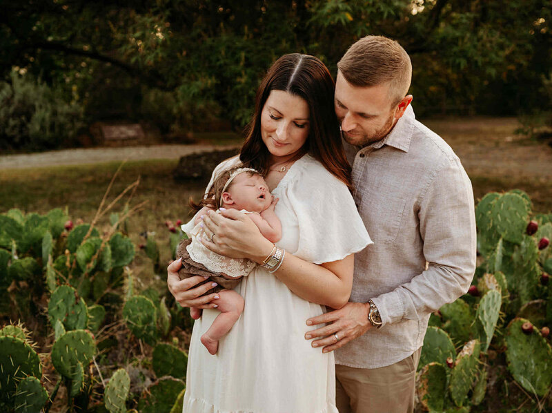 family of four playing with kids during their spring session with Paula Goforth a Fort Worth Family Photographer. Family is playing at Northwest Community Park in Fort Worth, Texas