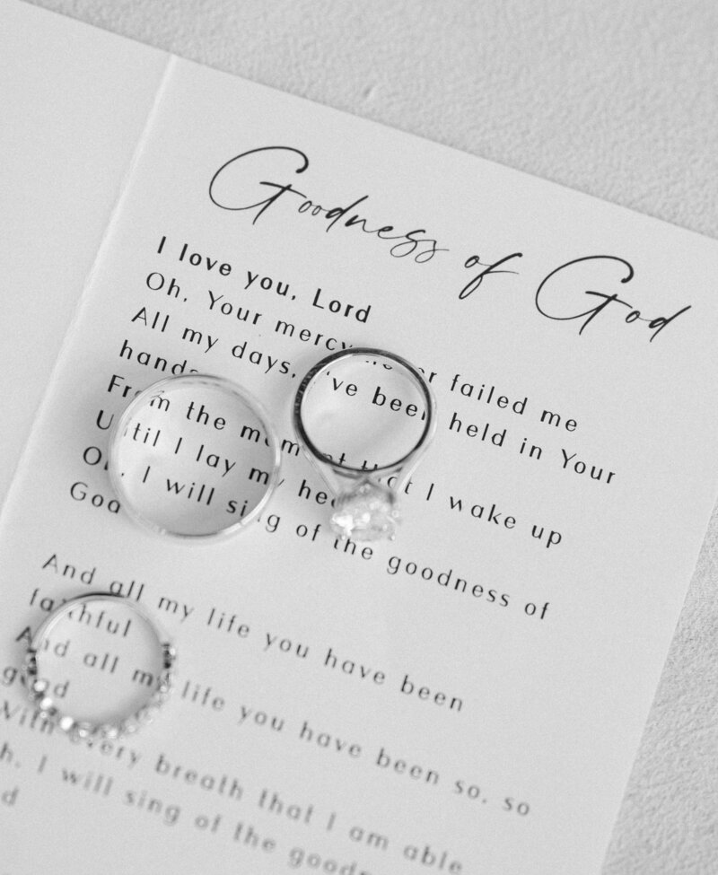 A wedding program with rings on it with word of the song the Goodness of God
