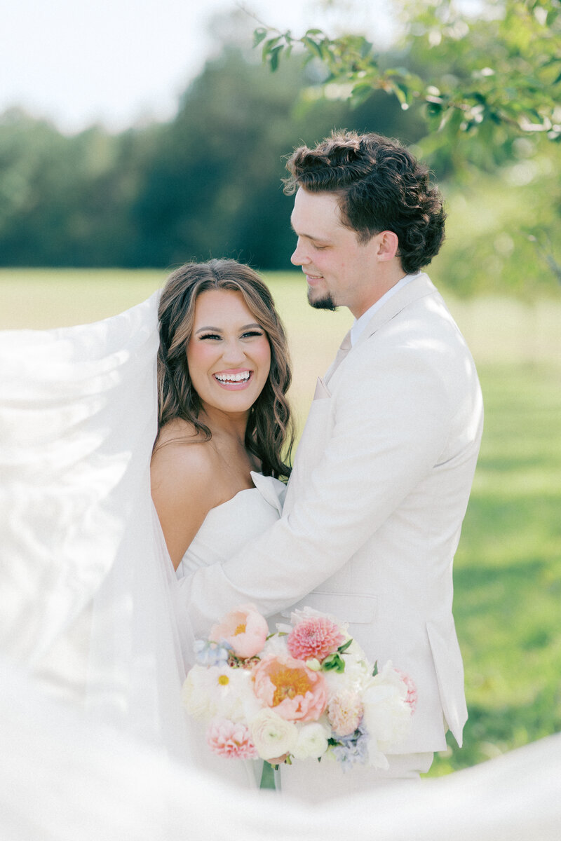 Black and white photo of groom with arm around bride