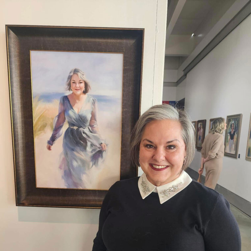 an older woman standing in front of her painted portrait