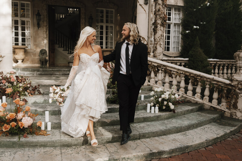 bride and groom walking out of  chateau in france