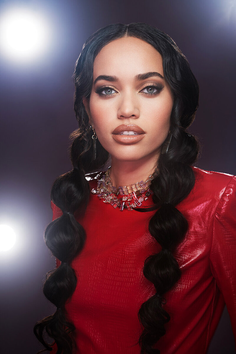 Confident portrait of Sena in a red outfit with sleek hair, captured by Ylva Erevall in bold lighting.