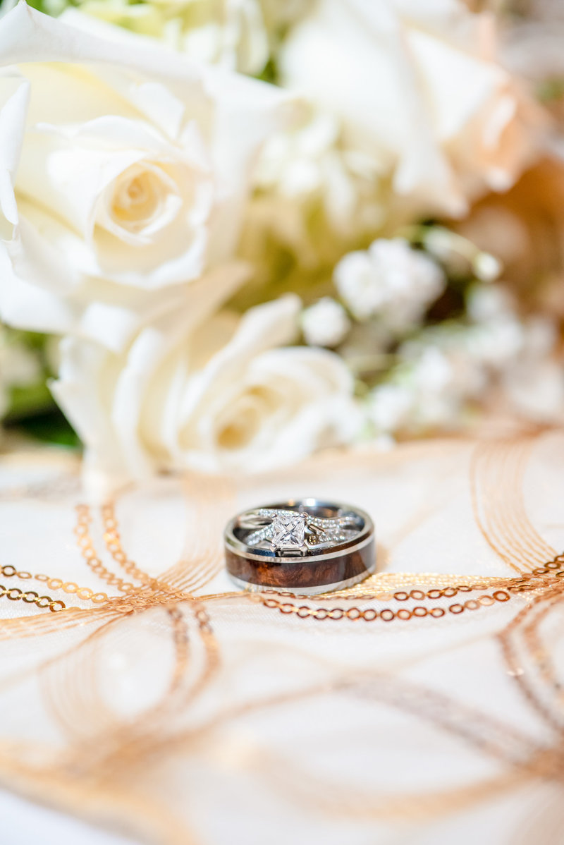 Wedding rings sit upon decorative gold filigree table cloth