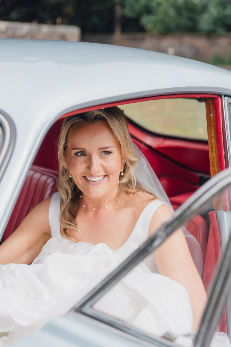 Bride in a car at a cheshire wedding. light and airy cheshire wedding photographer