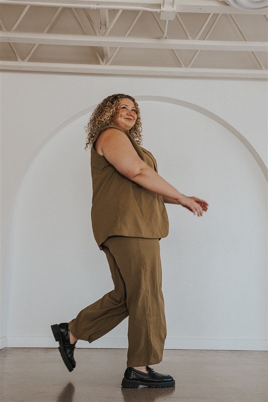 A woman smiling and walking across a room