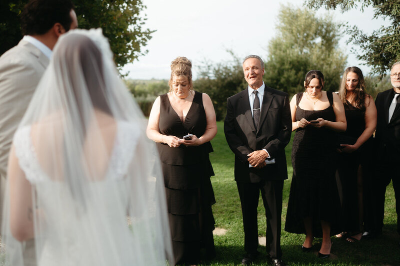 Elopement Ideas with Family | Groom's parents read heartfelt letters during an elopement ceremony, bride and groom are in the foreground