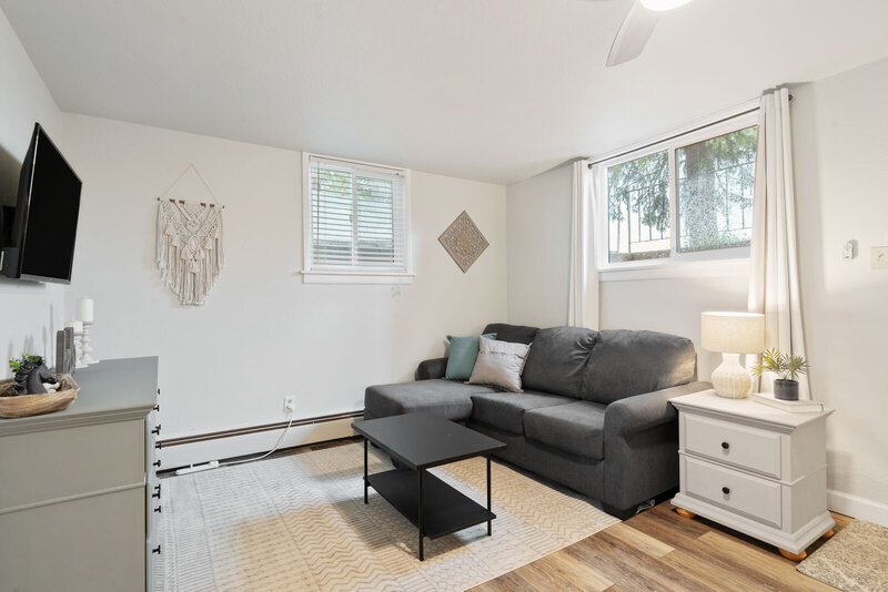 living room with grey couch and white end table