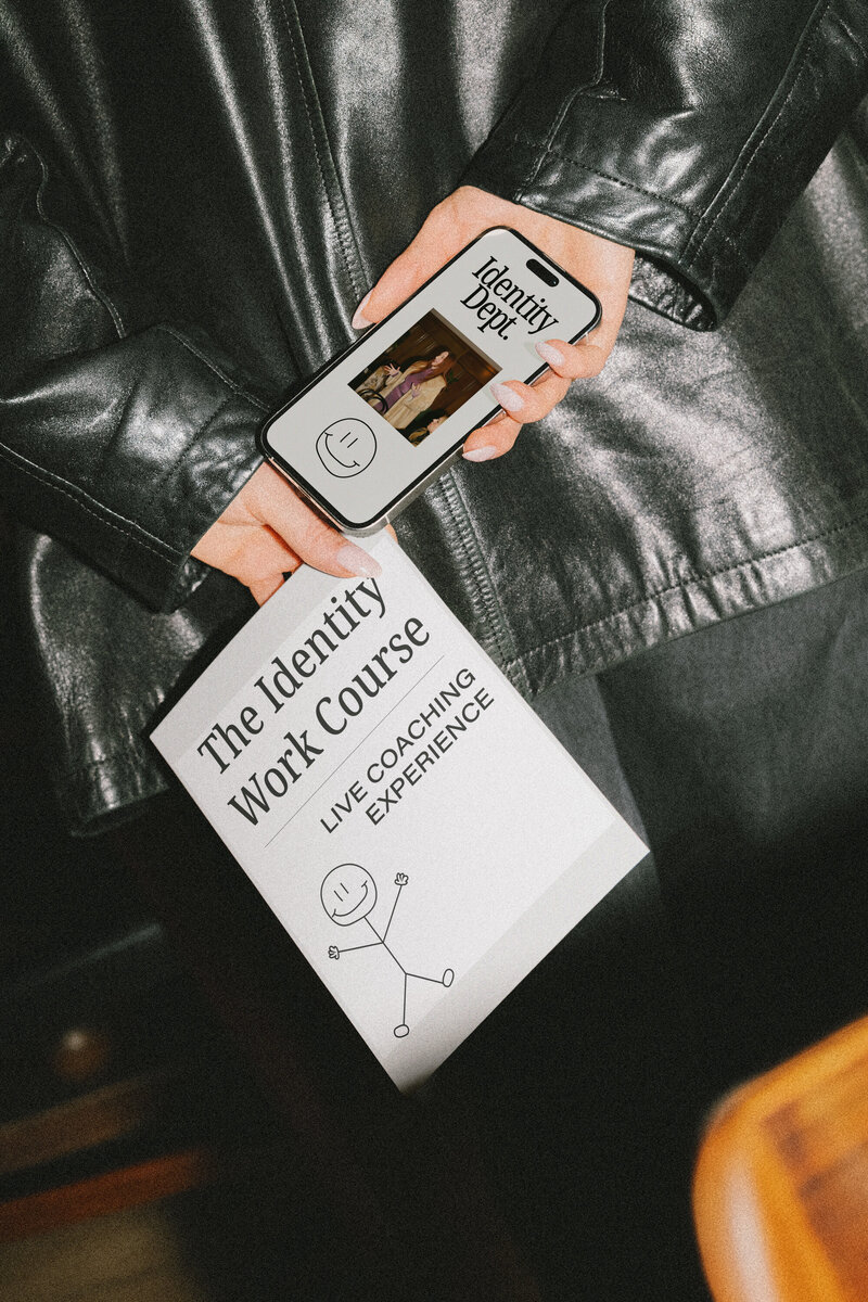 Female Founder holding a piece of paper and cell phone behind her back