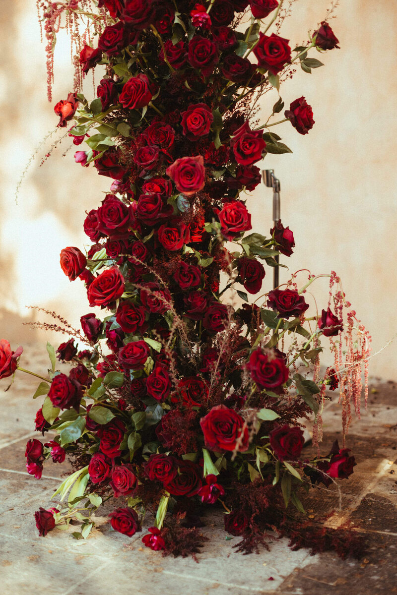 Bold red rose floral installation for romantic Arizona wedding ceremony