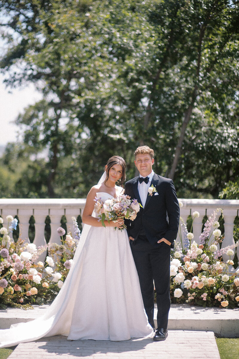 Bride and groom standing side by side at outdoor luxury wedding | Something Borrowed Event Company