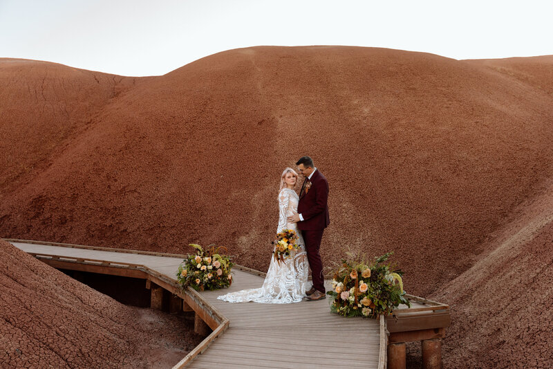 Couple embracing on a boardwalk at Painted Hills.