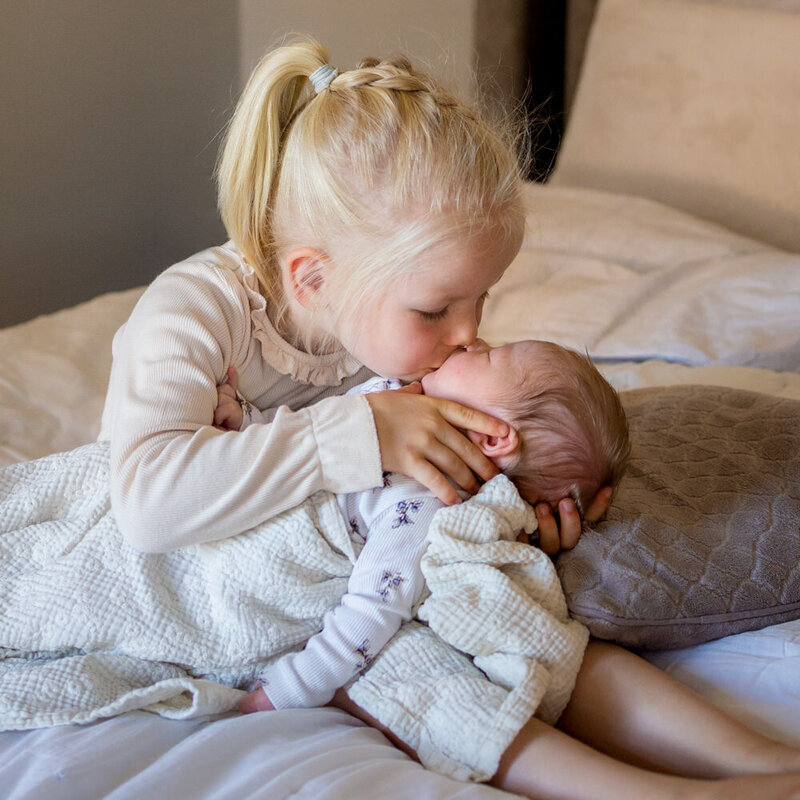 newbornshoot knuffelfoto baby met  grote zus