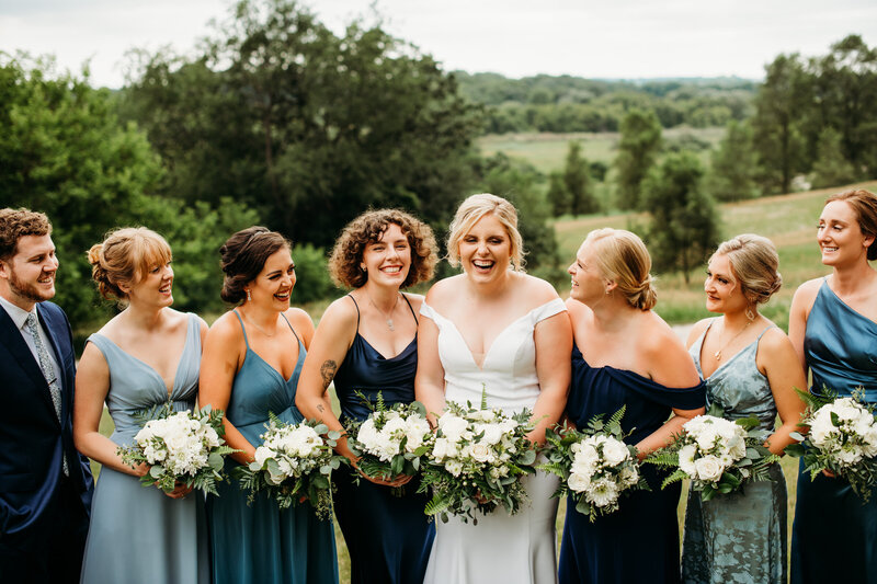 Bride with bridesmaids smiling and surrounding her