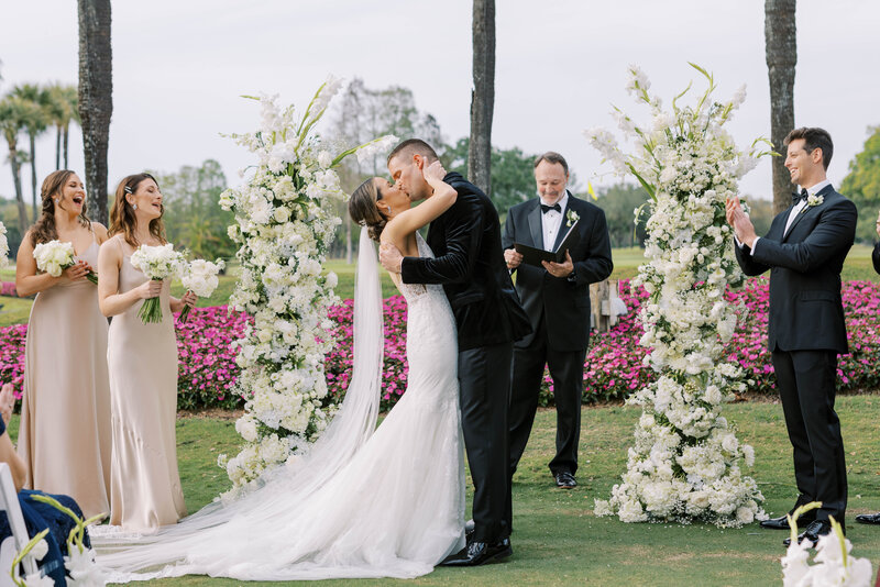 Bride and groom kissing at luxury outdoor wedding ceremony