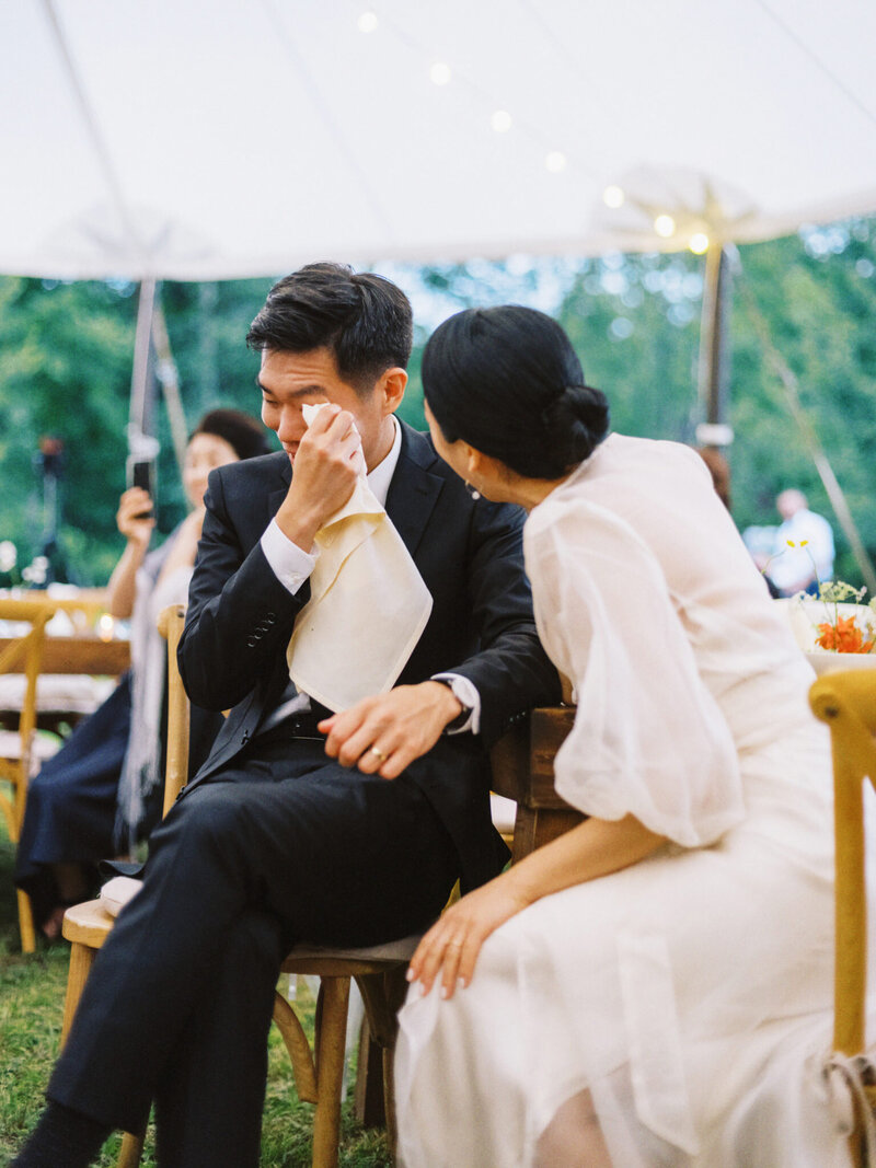 groom wipes away tears during reception toasts