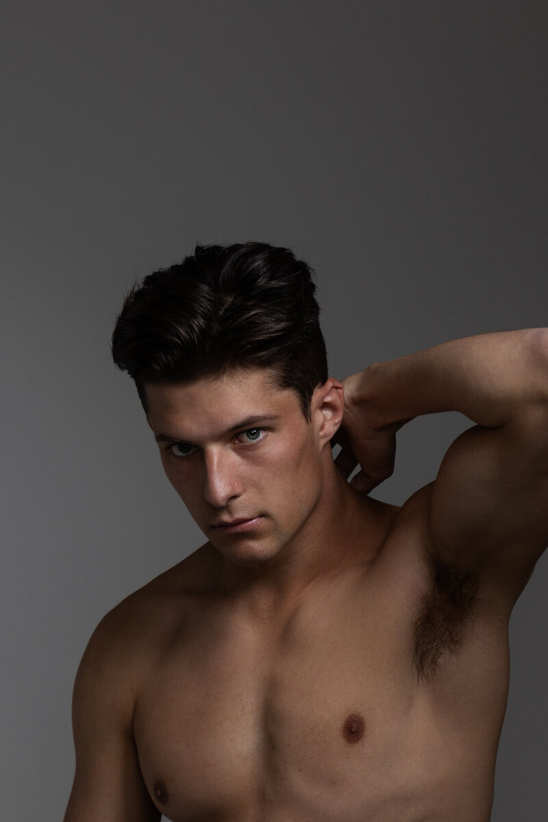 man flexing muscles, looking at camera