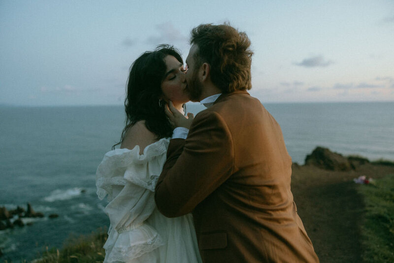 couple sharing a kiss in front of the ocean
