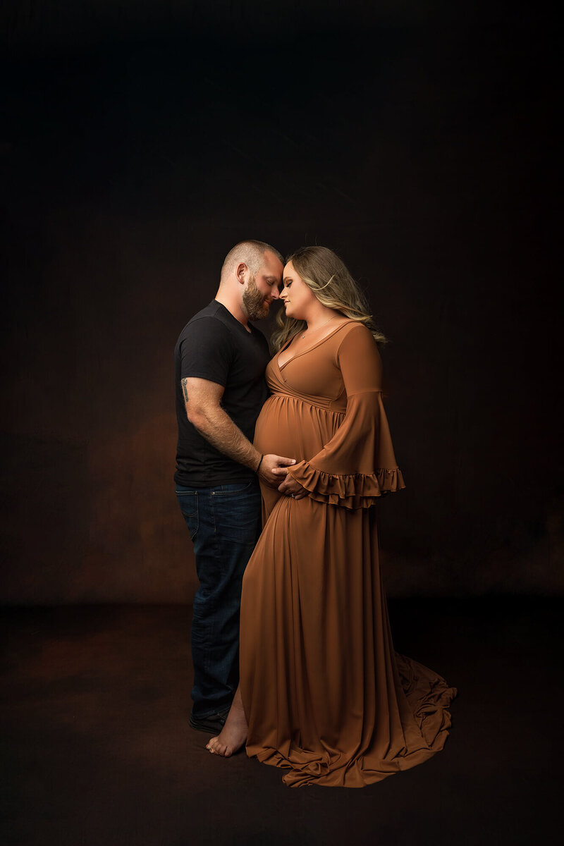 Expecting mother poses with her husband during her maternity session.