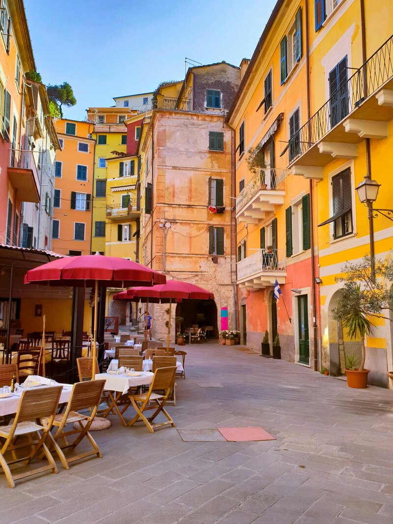 A street with umbrella, tables, and chairs