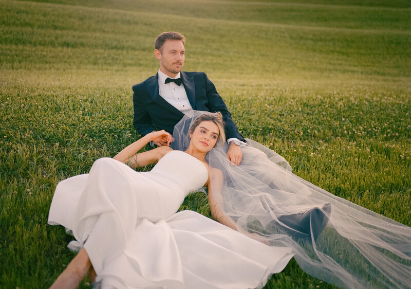 bride and groom walking through grass