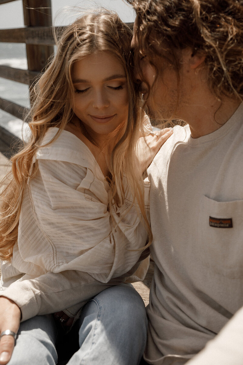 couple embraces for engagement photos in san diego
